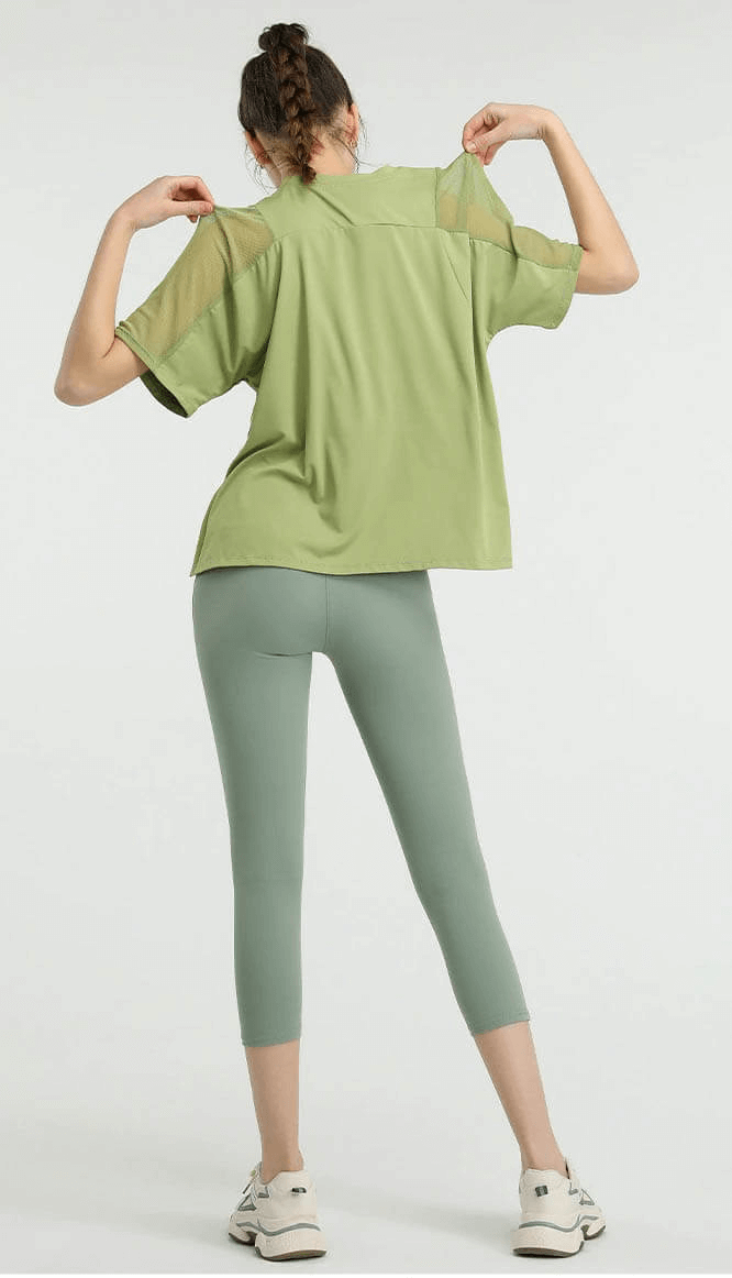 Woman wearing green loose running mesh short sleeves t-shirt, showcasing breathable workout sports clothing for active women.